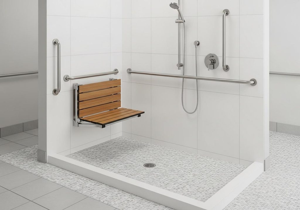 Accessible shower with a fold-down seat, grab bars, and handheld showerhead.