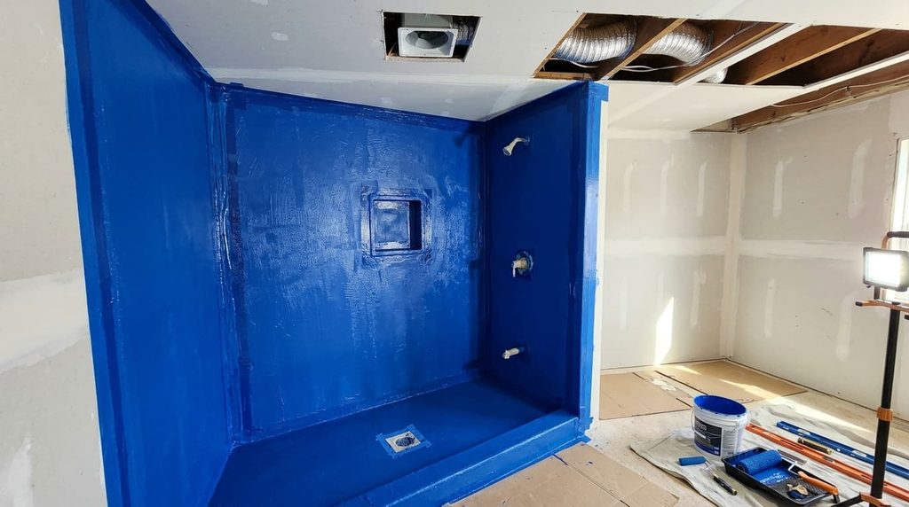 Shower walls with waterproofing membrane and exhaust fan duct during a bathroom remodel