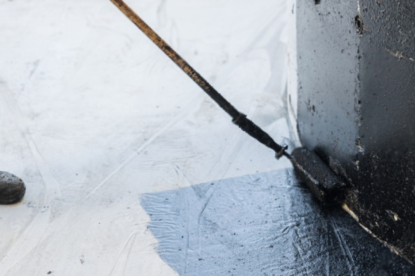 basement waterproofing membrane basement waterproofing coating. A worker applies bitumen mastic to the foundation.